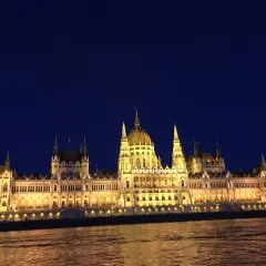 Budynek Parlamentu w Budapeszcie nocą, oświetlony, z odbiciem w Dunaju. Ceny w Budapeszcie mogą być różne, ale widok jest bezcenny.
