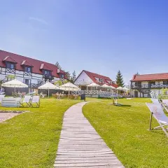 Słoneczny dzień na Mazurach. Urokliwe mazurskie miejscowości zapraszają do wypoczynku. Leżaki i parasole czekają na gości przy hotelu.