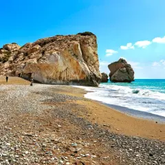 Skały i plaża na Cyprze, wyspie Afrodyty. Turkusowe morze i błękitne niebo tworzą idealne tło dla tej malowniczej scenerii.