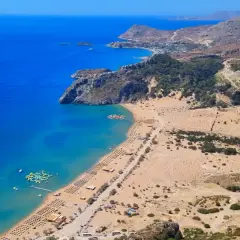 Malownicze plaże Rodos z turkusową wodą, leżakami i wodnym parkiem rozrywki. Widok z góry na wybrzeże i górzysty krajobraz.