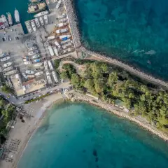 Widok z lotu ptaka na port i plażę w Kemerze, Turcja. Widać liczne jachty, łodzie, budynki i zielone tereny. To idealne miejsce na odkrywanie atrakcji Kemer.