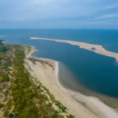 Piaszczyste wyspy na morzu śródziemnym, otoczone turkusową wodą i zielenią.