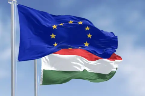 Flaga UE i Węgier powiewają na wietrze. Czy na Węgrzech można płacić euro? Oficjalnie nie, ale euro jest szeroko akceptowane.