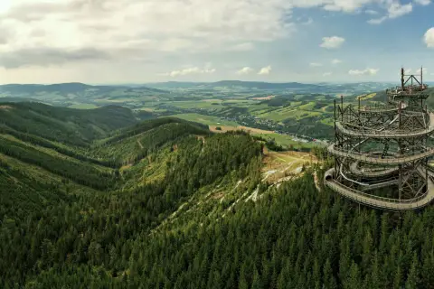 Widok na malowniczą dolinę Morawy z górującą nad lasem, spiralną wieżą widokową.