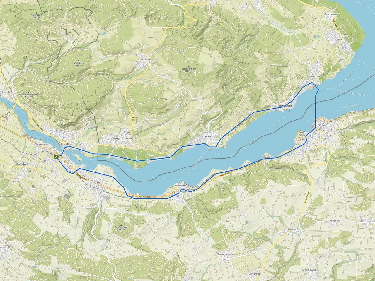 Mapa przedstawia malowniczy odcinek rzeki Ren, otoczony zielonymi wzgórzami i urokliwymi miejscowościami.