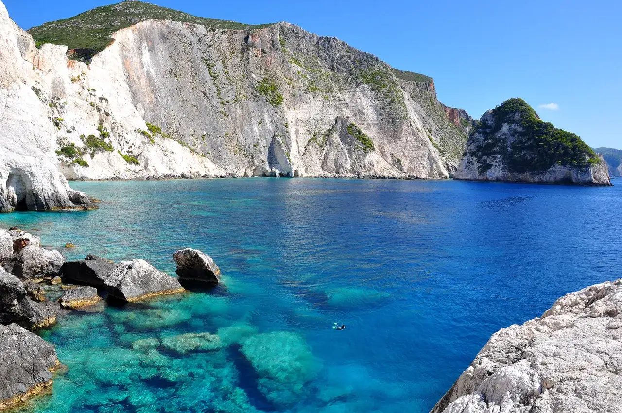 Turkusowa woda i białe klify na Zakynthos. Idealne miejsce na wycieczki fakultatywne i snorkeling.