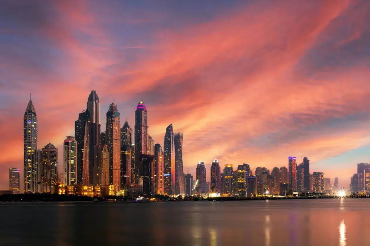 Zachód słońca nad Dubajem, z jego lśniącymi wieżowcami, odzwierciedla bogactwo i wysokie ceny w Dubaju.